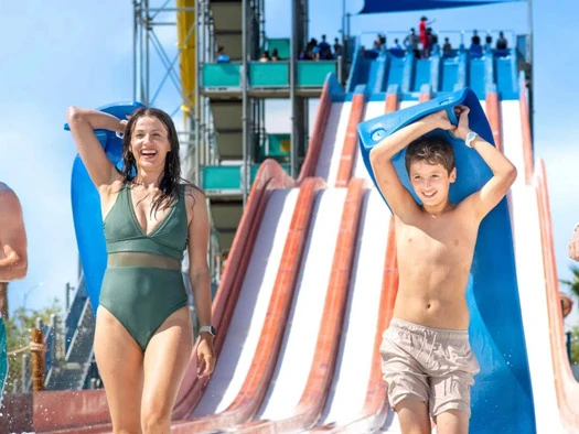 Mother and son holding mat near slide.